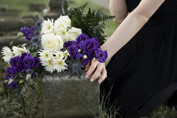 close-up-woman-visiting-grave-loved-one
